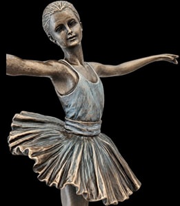 Ballerina statuette placeret på reol sammen med bøger og blomster – interiørinspiration